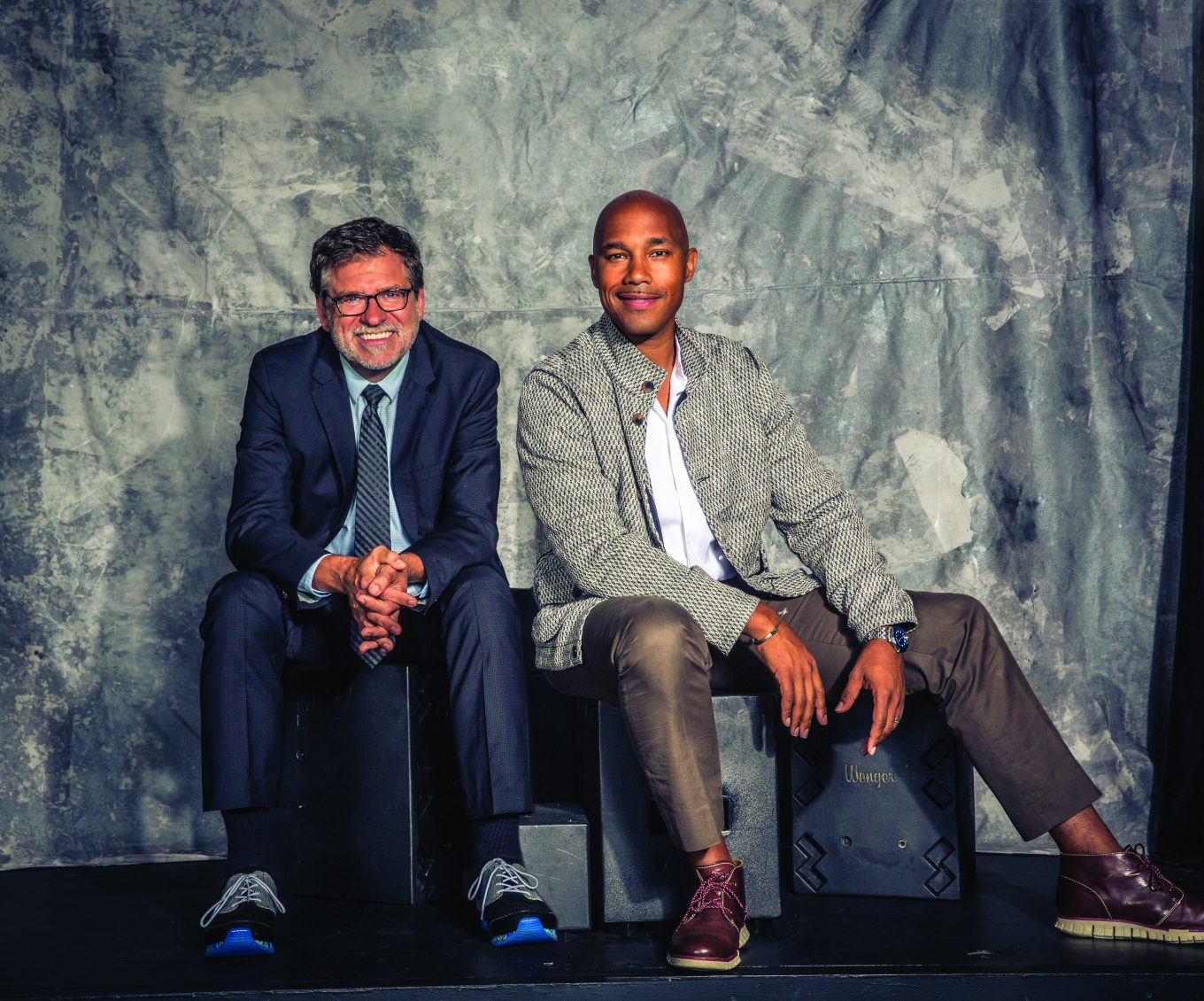 David Dower and David C. Howse sitting together in front of a gray backdrop
