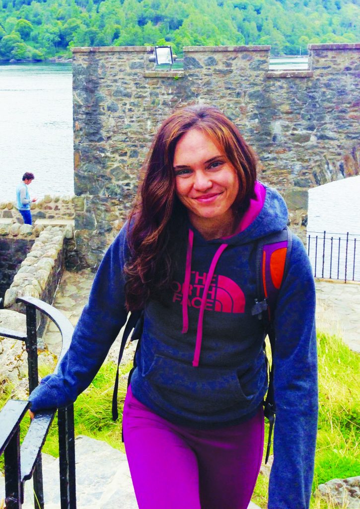 Photo of Laura Lewis climbing stairs in Scotland wearing a North Face hoodie