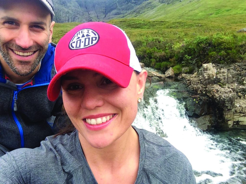 Laura Levis and her husband standing in front of a waterfall