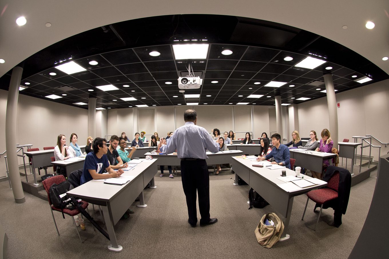 A professor standing in front of a classroom delivering a lecture to students
