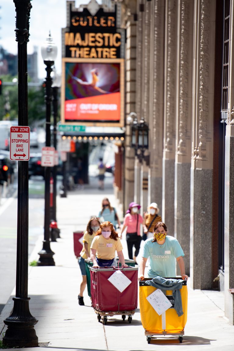 Students on the sidewalks pushing moving bins in front of the Cutler Majestic Theatre