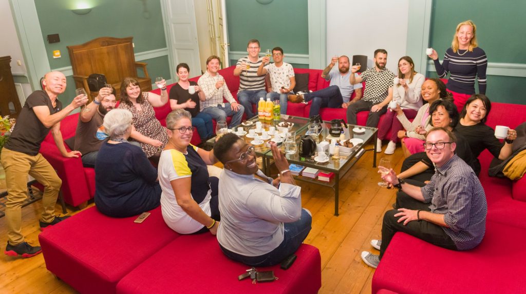 Alums sitting together enjoying food and drink