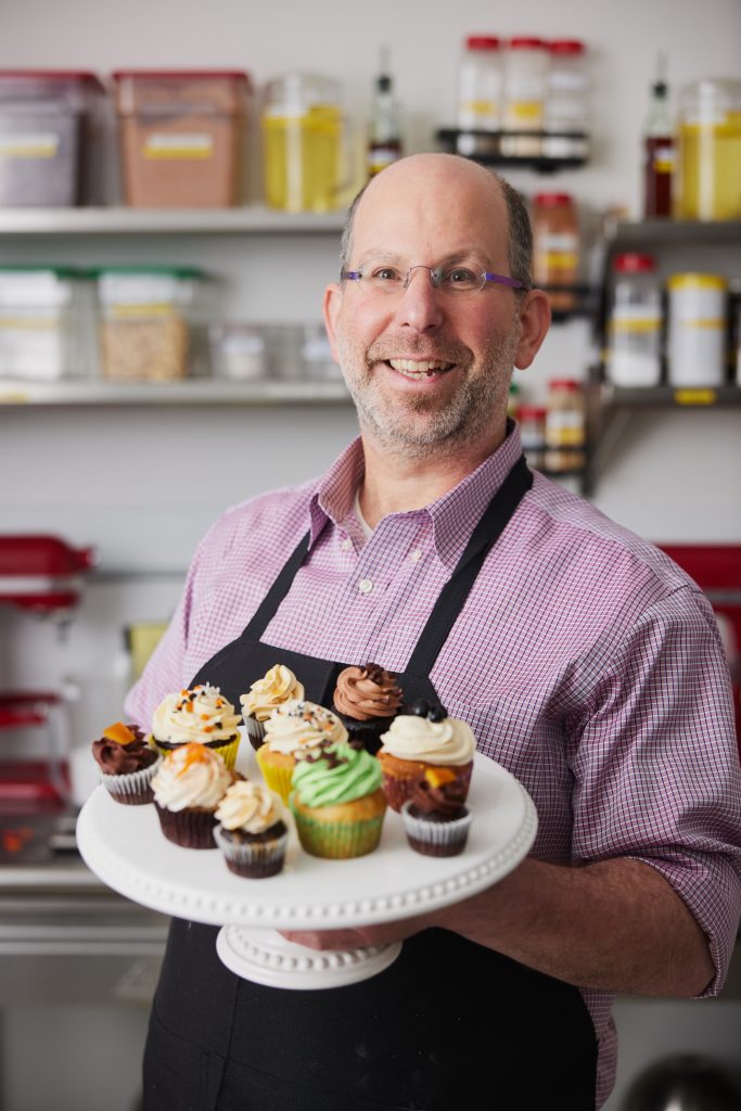 Rik Lemoncello holds a plate with lots of cucpakes