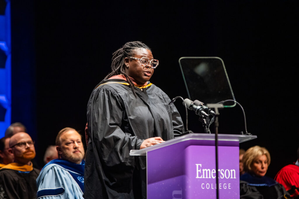 Boston Poet Laureate Porsha Olayiwola reads their poem from a lecturn