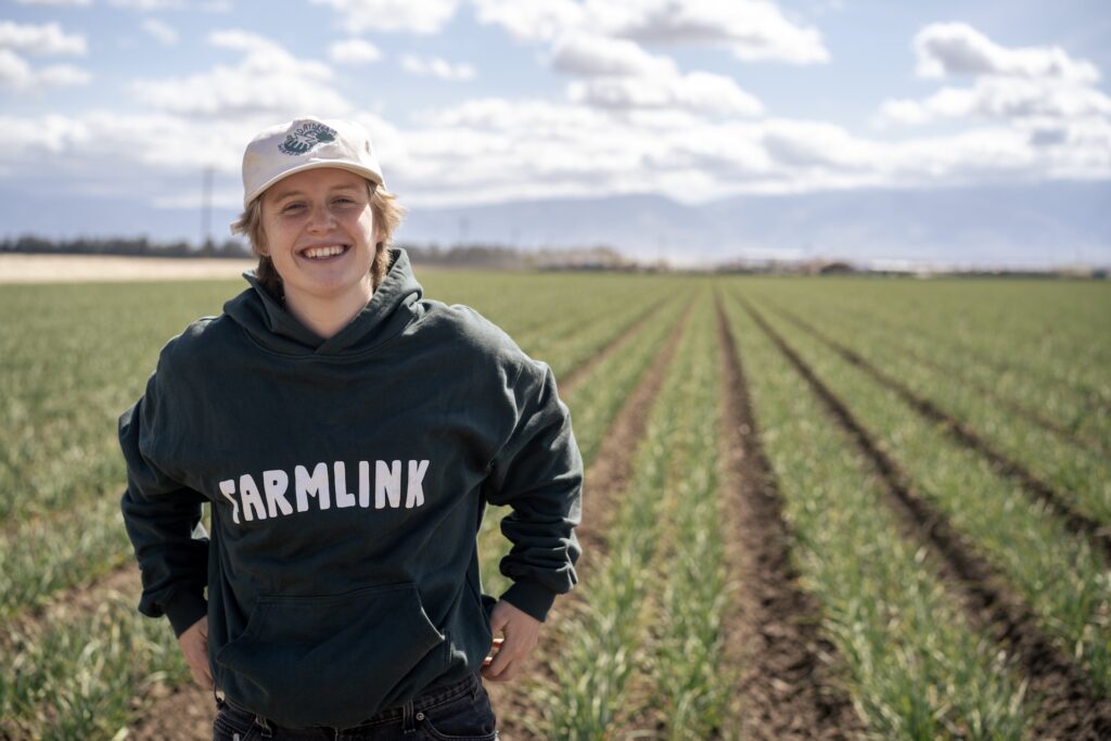 Kate Nelson stands in a field on a farm