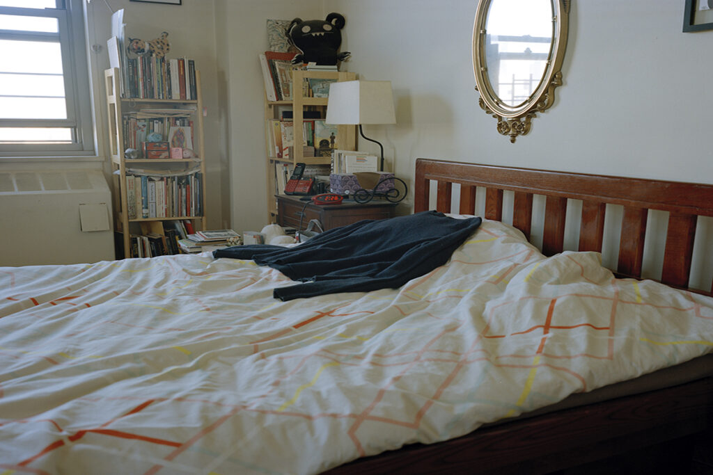 A bed with an item of clothing on it